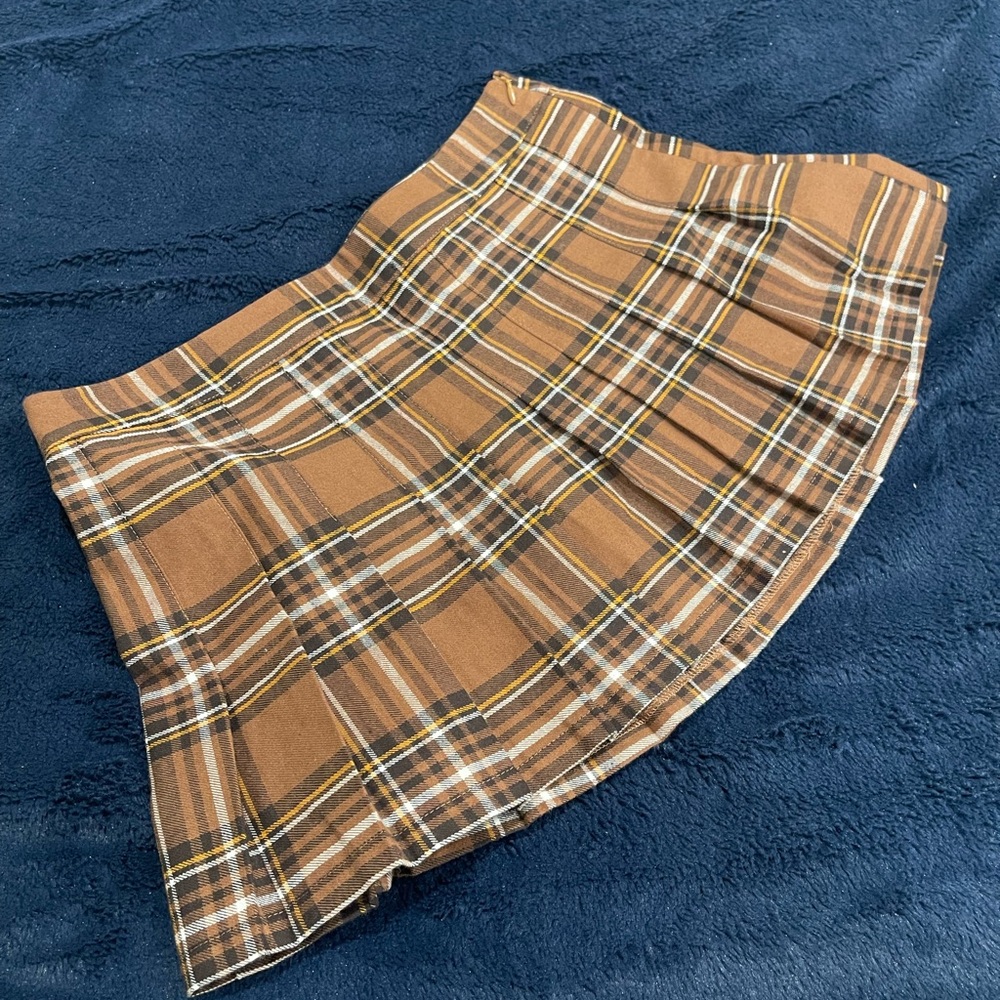 A woven allover plaid pattern, pleated A-line silhouette, and mini length Medium